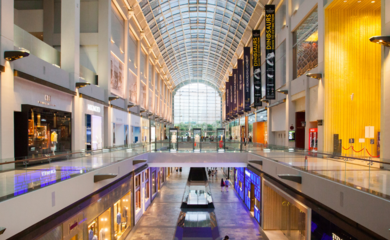 An expansive view of a large glass ceiling and floor levels in a large shopping centre.