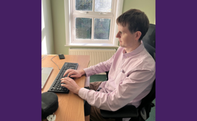 Callum Russell sits at a desk using a computer.