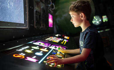 A child interacting with light up controls at Winchester Science centre