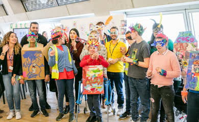 Group of children wearing artistic masks and headdresses 