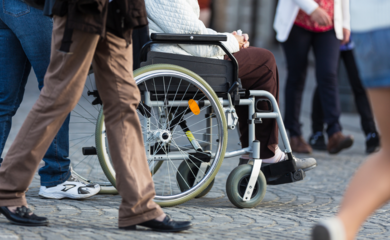 Wheelchair wheels with people walking past