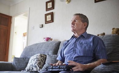 Visually impaired man sitting on a sofa using a tablet