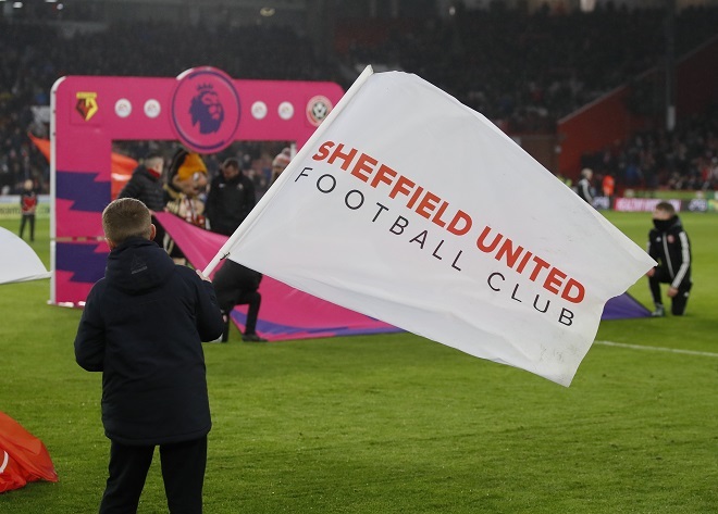 Football fan waving a flag which says Sheffield United Football Club on it