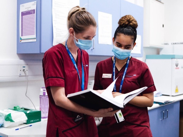 "Nurses looking at the notes for the day during a shift handover"