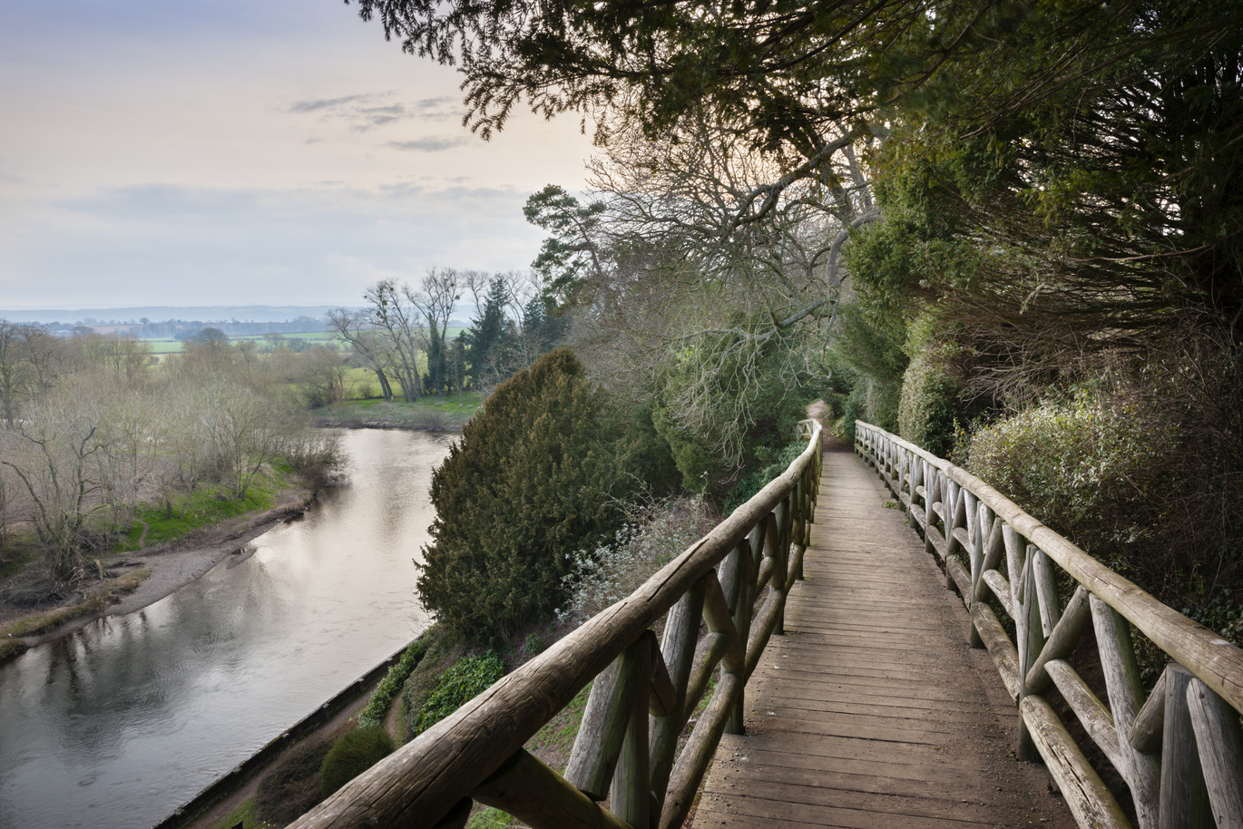 The River Wye from the foot bridge at the top of the garden, surrounded by many trees.