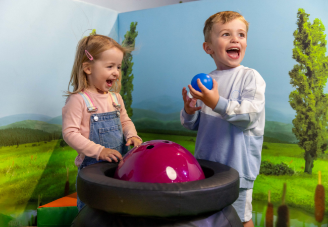 children holding a blue and purple ball
