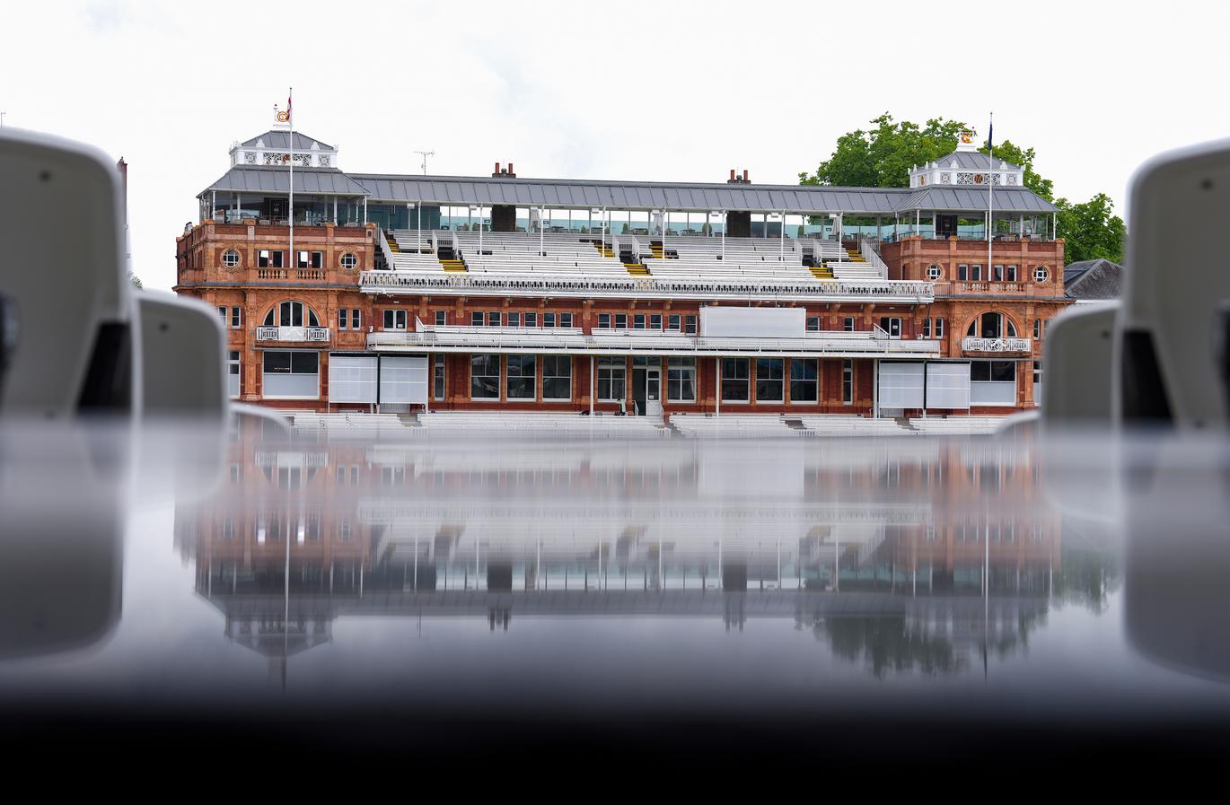view of the pavilion from the stands, pavilion reflected in the rains soaked stand opposite.