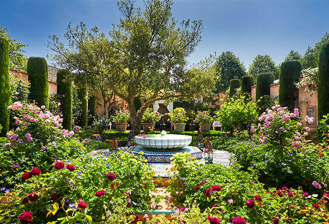 "Carpet Garden, luscious green gardens surrounding a water feature sculpture"