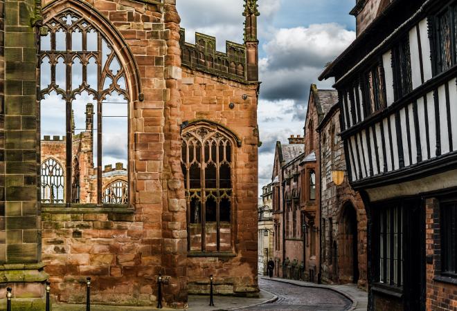 "A Coventry street at dusk with tudor style buildings"