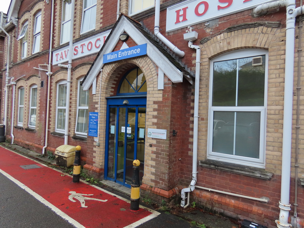 red brick building with blue door and red pedestrian area 