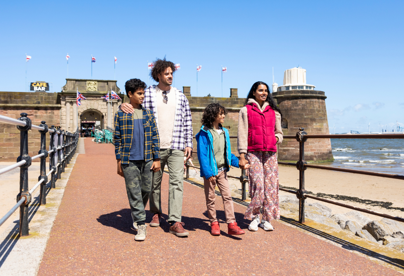 A family walk along a costal path in the sunshine 