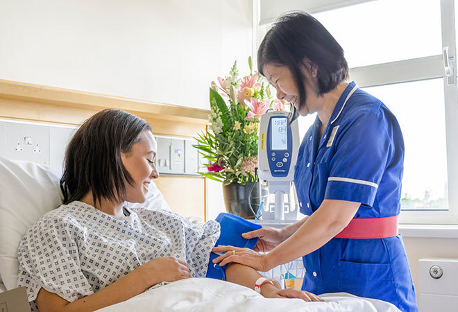 "Nurse caring for patient in bed"