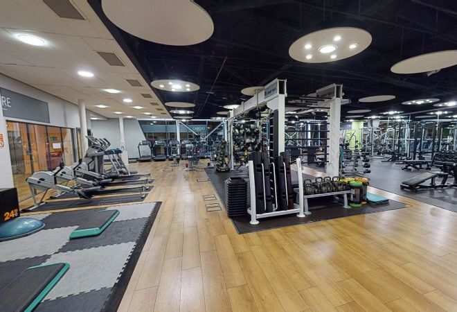 ''inside of the gym. rowing and step machines to the left. kettlebell and climbing frame to the centre''