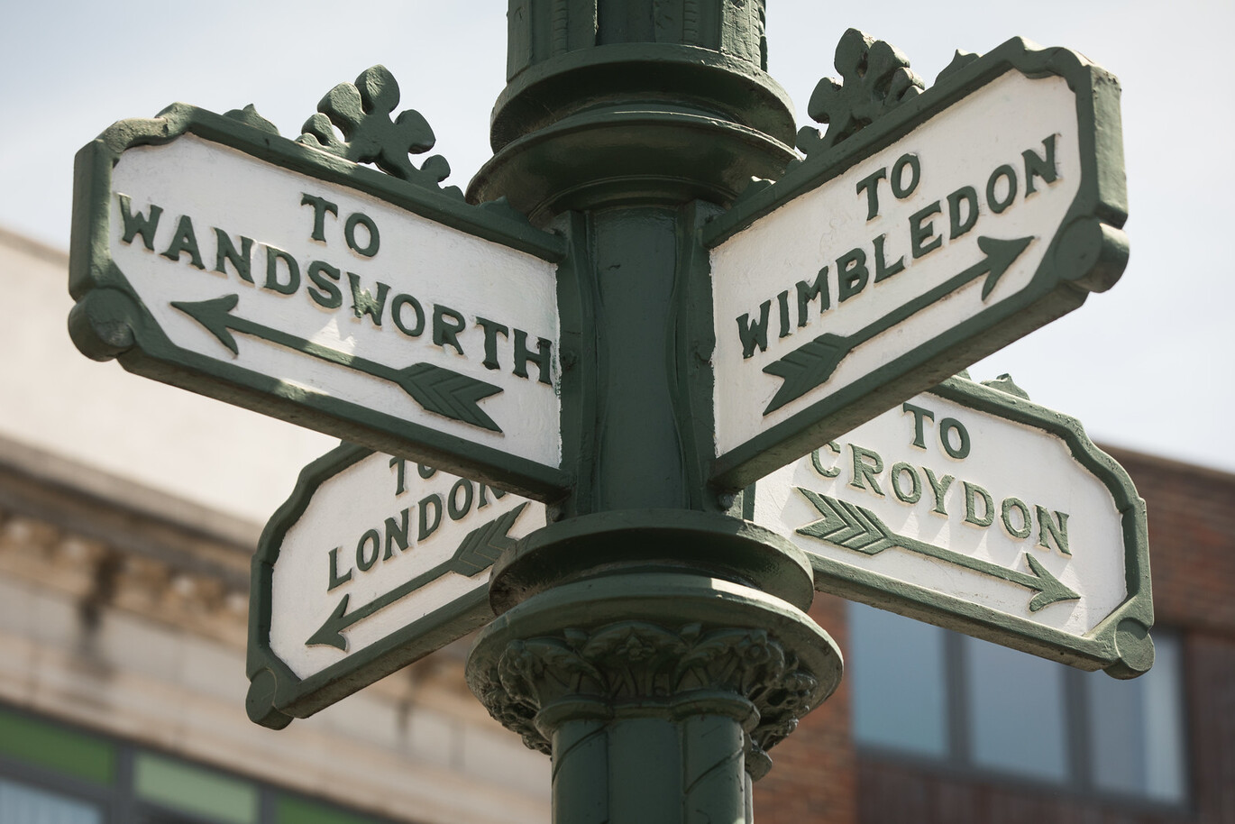 Signpost pointing 4 directions, it is pointing to Wimbledon, Wandsworth, Croydon and London