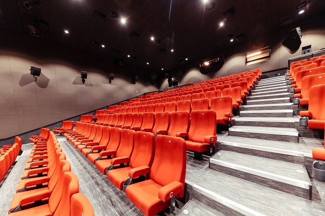 "Photo of inside the theatre when empty, with tiered red seating throughout"