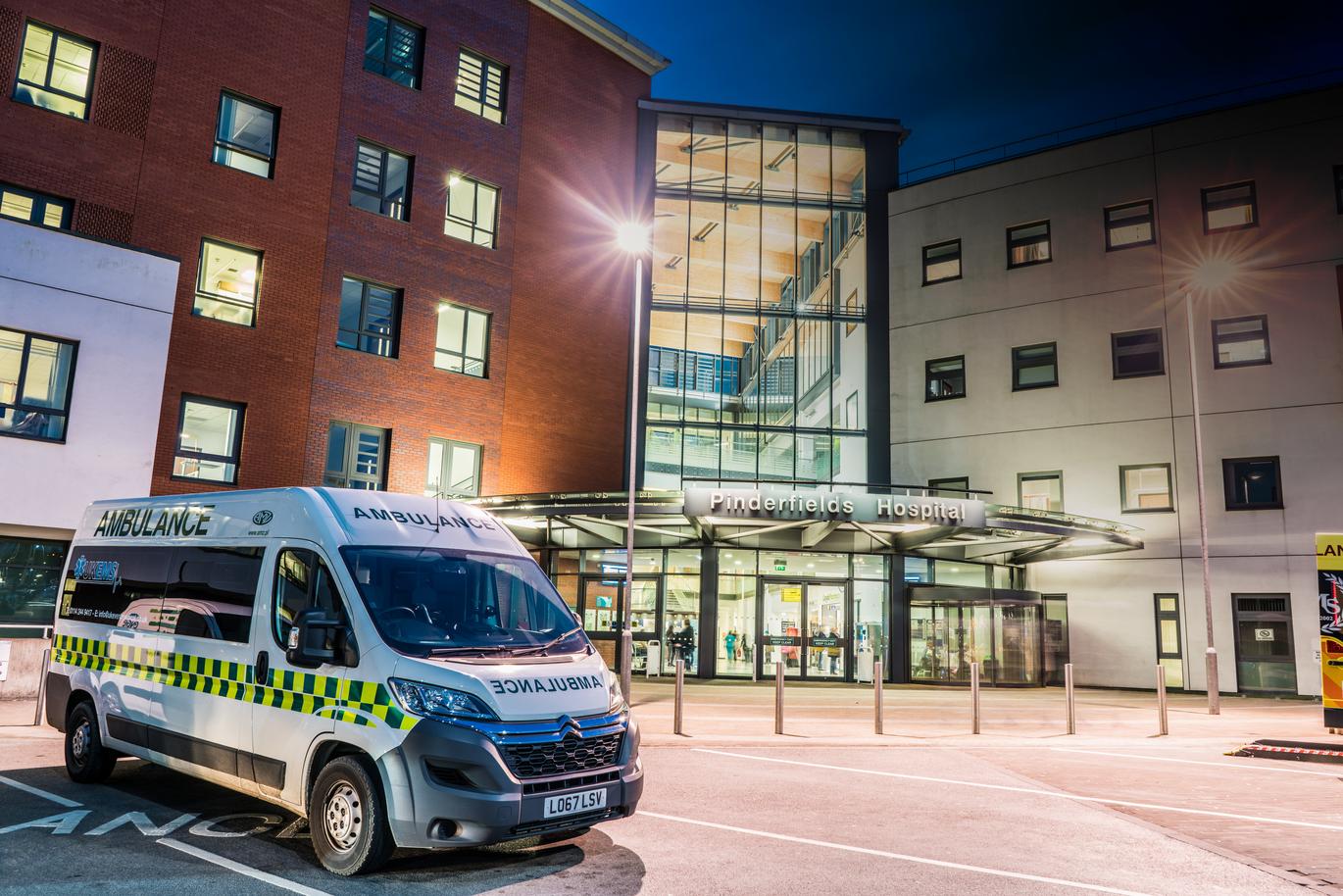 "Pinderfields Hospital main entrance at night with an ambulance parked outside"