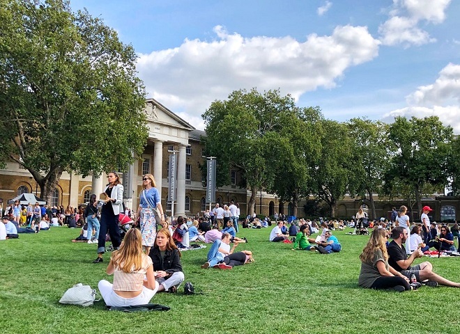 Photo of people sitting on a grass area outside of Saatchi Gallery