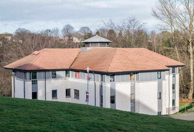 "External image of Halls of Residence building with an orange roof and grass in forefront"