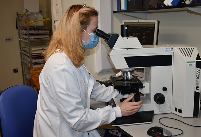'photo of a Biomedical Scientist looking into a medical telescope'