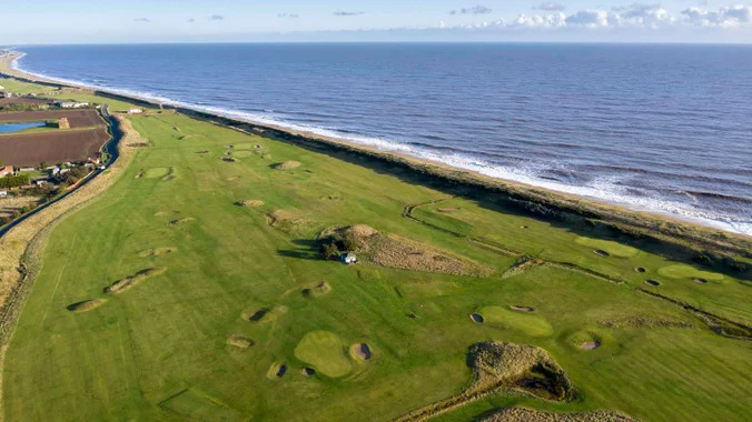 Aerial view of the golf course directly on the sea edge.