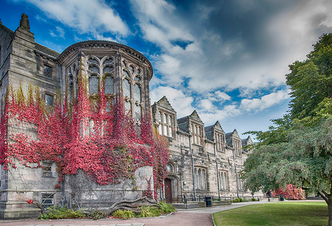 "University building with autumnal trees and ivy on façade of building" 