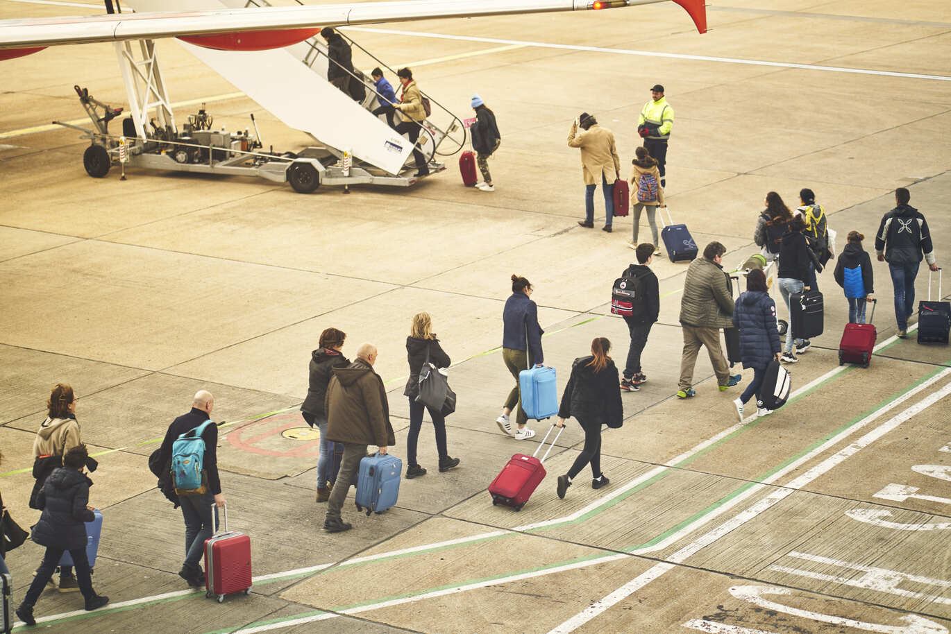 "Aerial shot of people queuing to board an aeroplane"