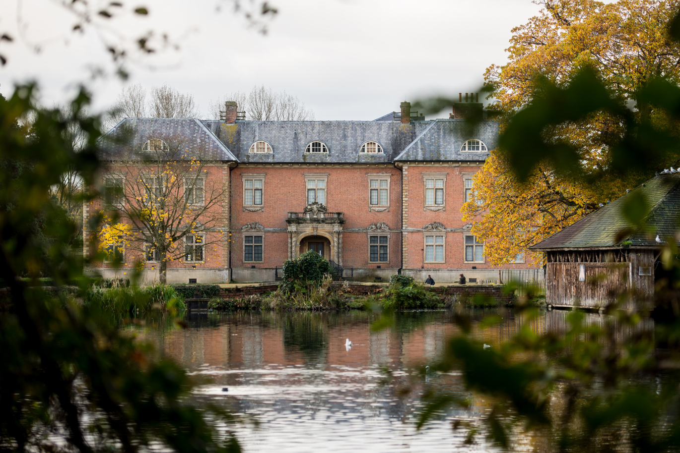 The lake and 17th century brick house in autumn.