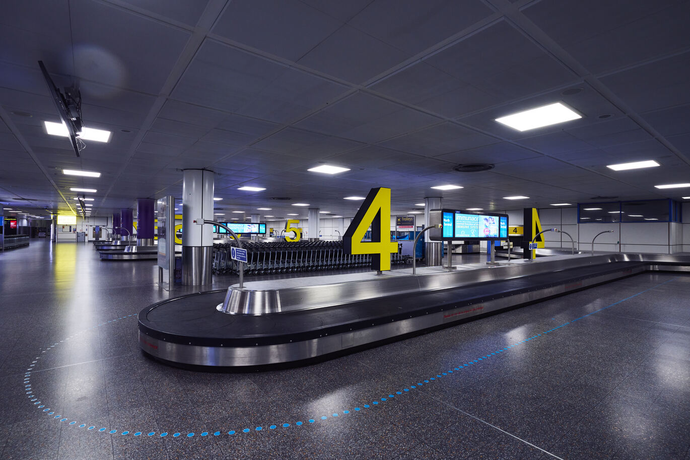 "Baggage belt at North Terminal Arrivals with a large yellow letter four"