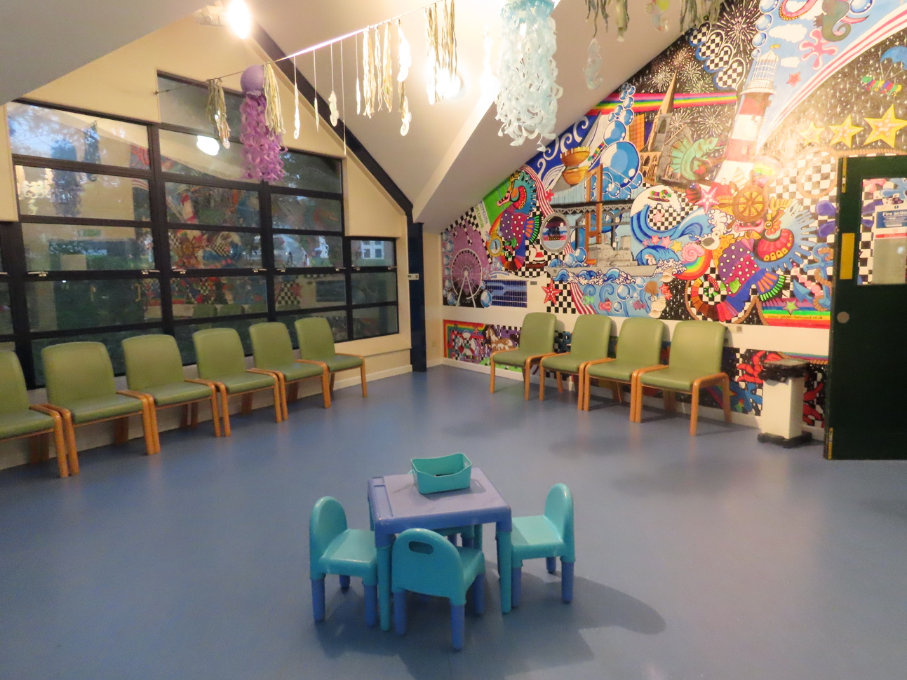 waiting room with chairs on the outside and table and chair in the centre 