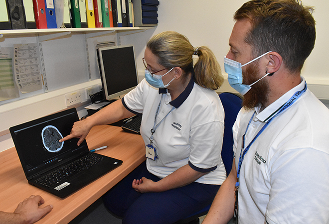'photo of staff looking a a scan on a computer'
