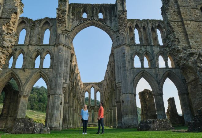 Rievaulx Abbey, woman is using a walking stick 