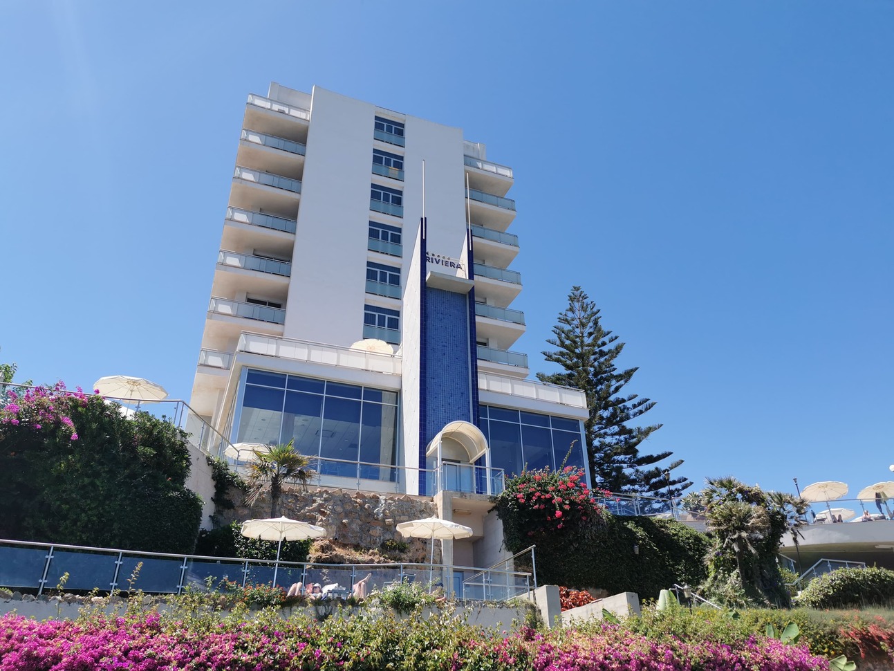 TUI Blue Riviera Hotel in background, purple flowers are in the foreground, the shot is taken from the beach"