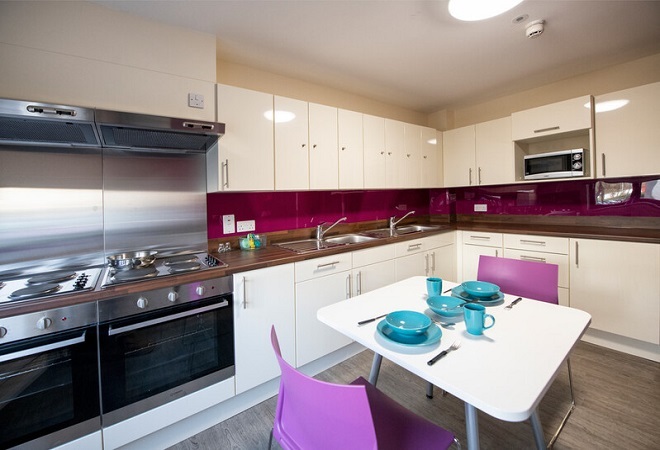 "Image of a kitchen with a small dining table and cooker"