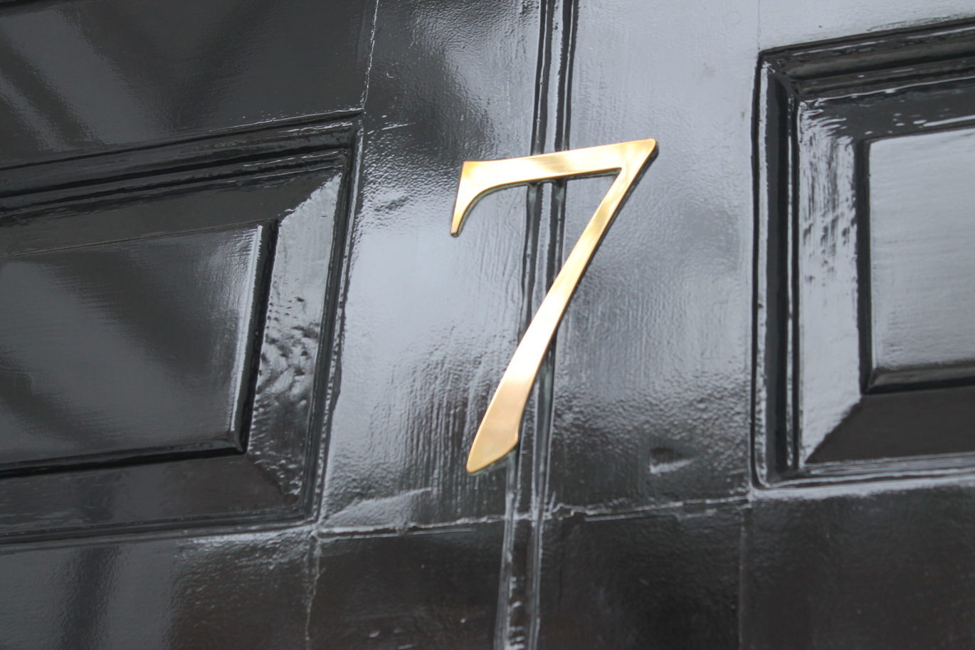 Close up of a black door with a number 7 on it