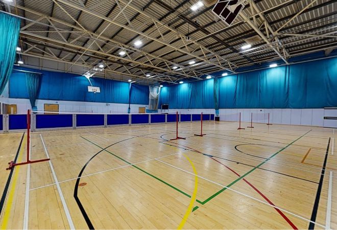 ''hall setup as for badminton. basketball net in background.
