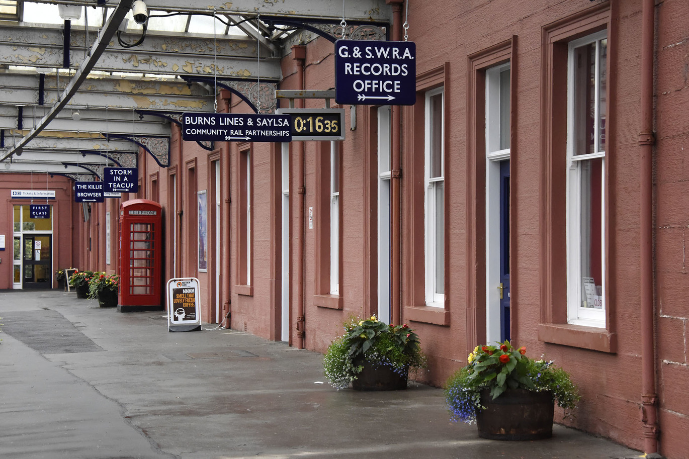 "East Ayrshire train station platform. building walls red sandstone."