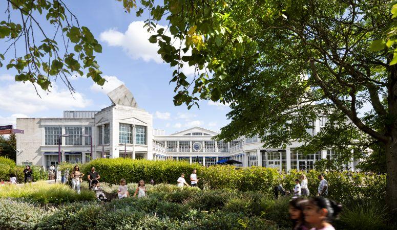 "Landscaped outdoor area at Bluewater with trees, planting, and people walking in front of the shopping centre."
