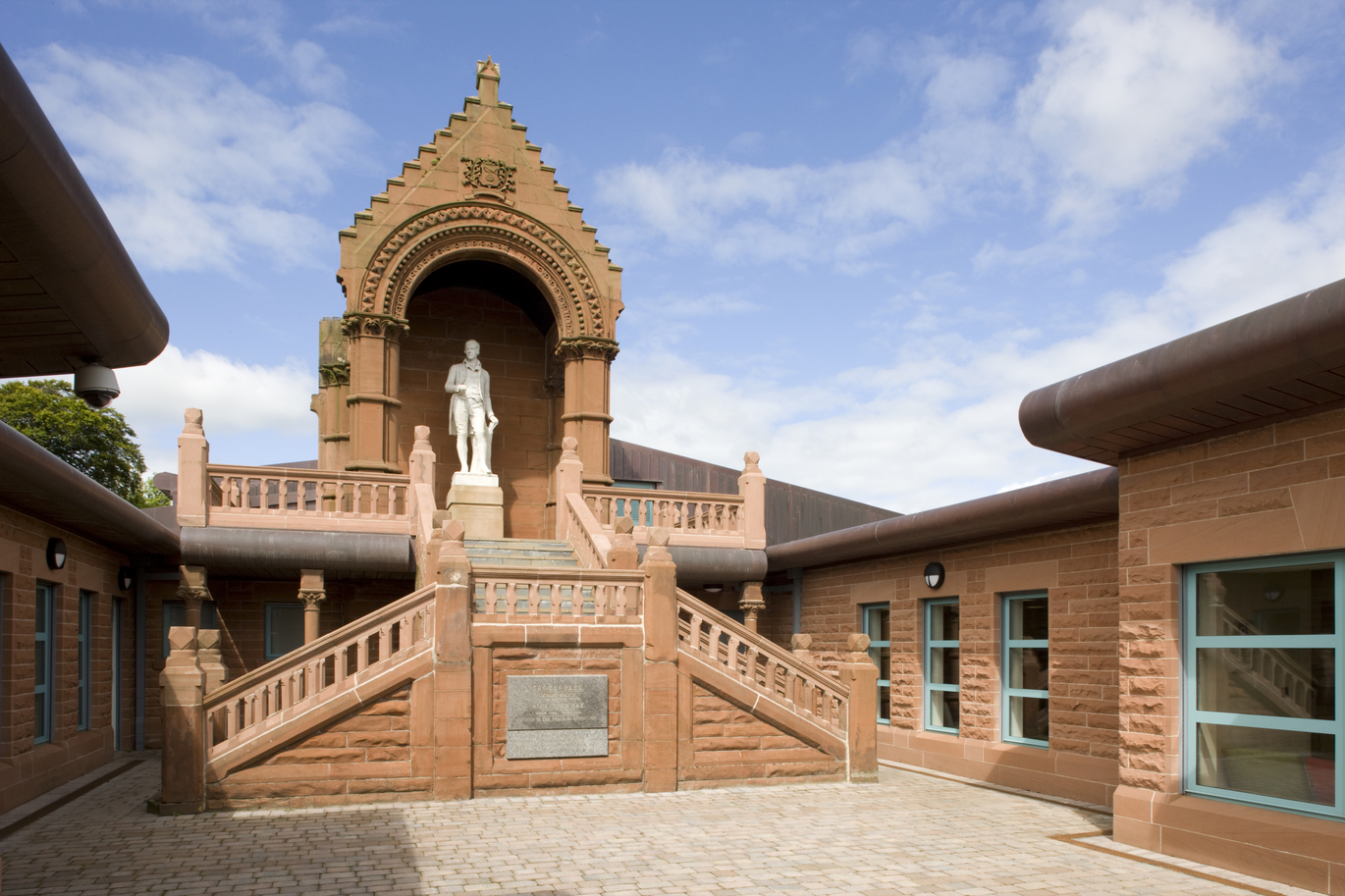 "East Ayrshire monument with stairs leading to monument set against blue sky with clouds"