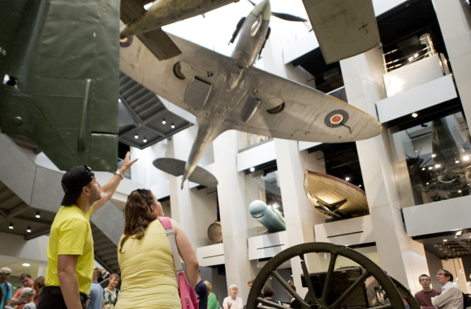People inside looking at a plane above them on show