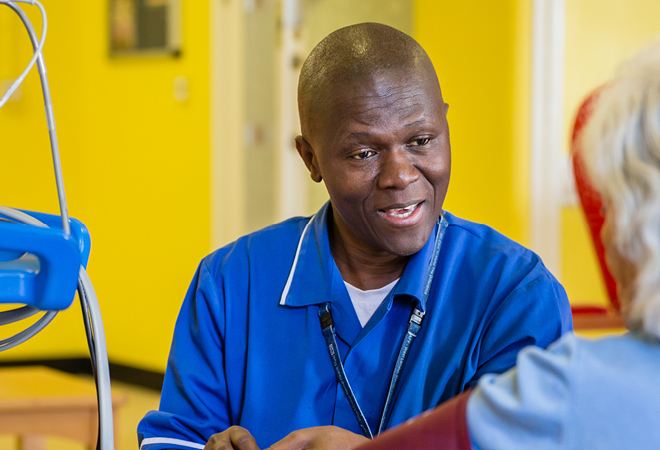 image of a West London NHS Trust member of staff smiling treating a patient 