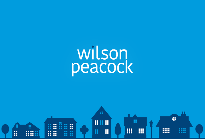 "Wilson Peacock logo on a light blue background, dark blue houses across the bottom"