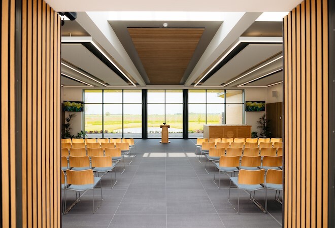 "Image depicts a view of the service hall from the entrance showing rows of chairs and the lecturn"