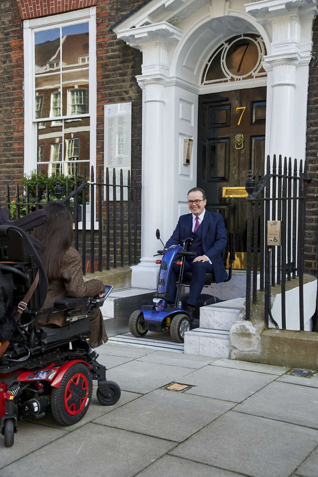 A man sitting on a mobility scooter outside of a building