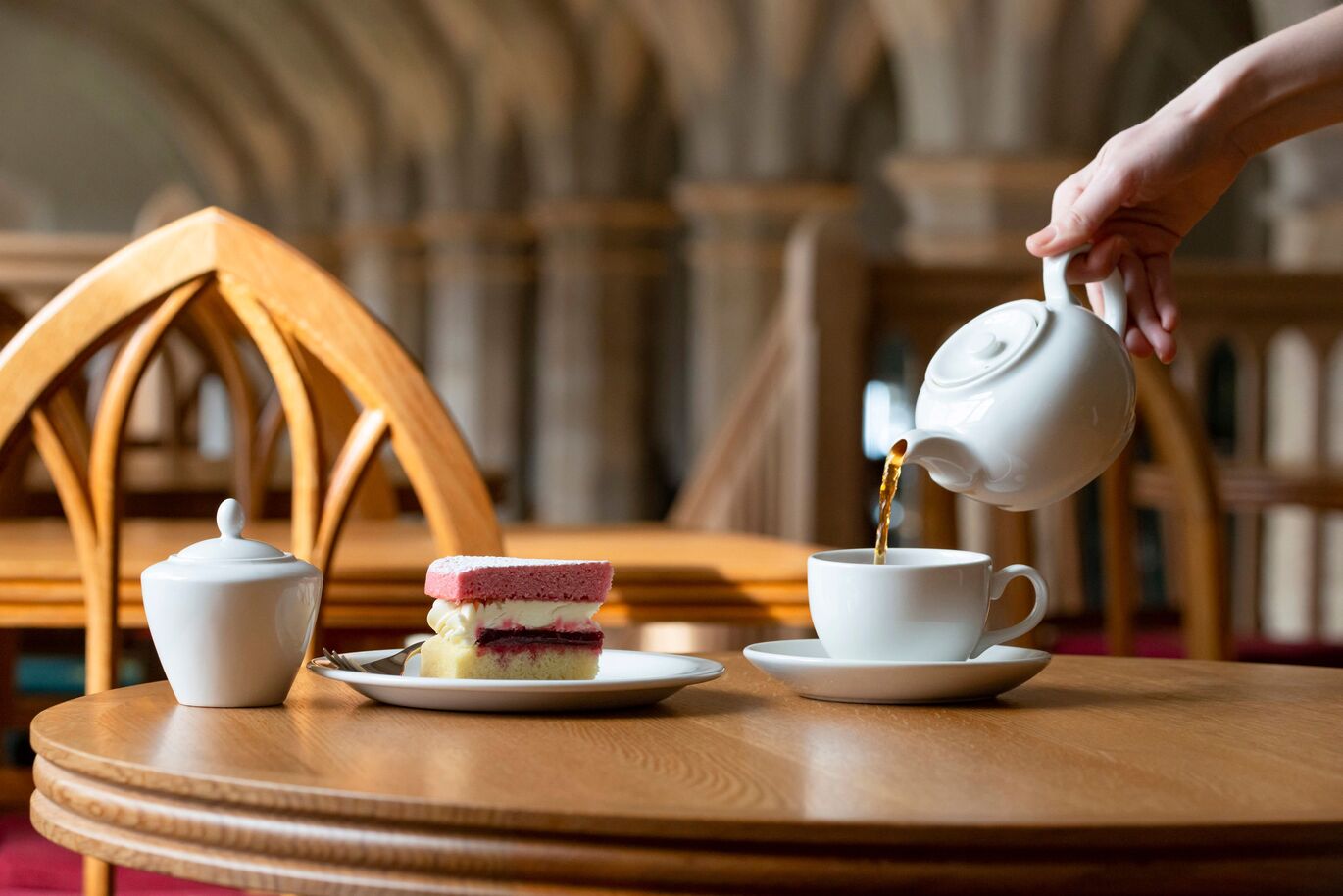tea at the Castle, cake on a plate and tea mid pour. Credit to Royal Collection Trust / © His Majesty King Charles III 2023