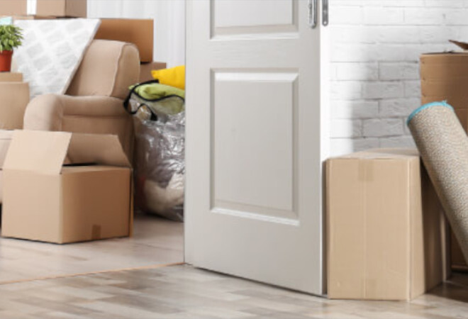 A doorway surrounded with cardboard boxes as if people are midway through moving house