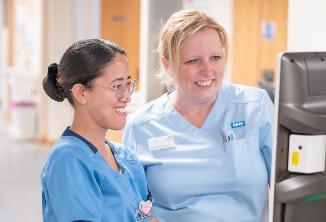 "West Suffolk Hospital staff looking at a computer screen"