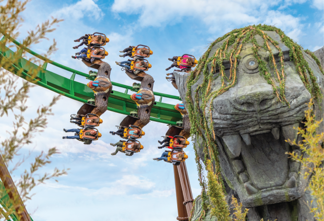 "A rollercoaster twists around a stone tiger, the ride is mandrill mayhem"