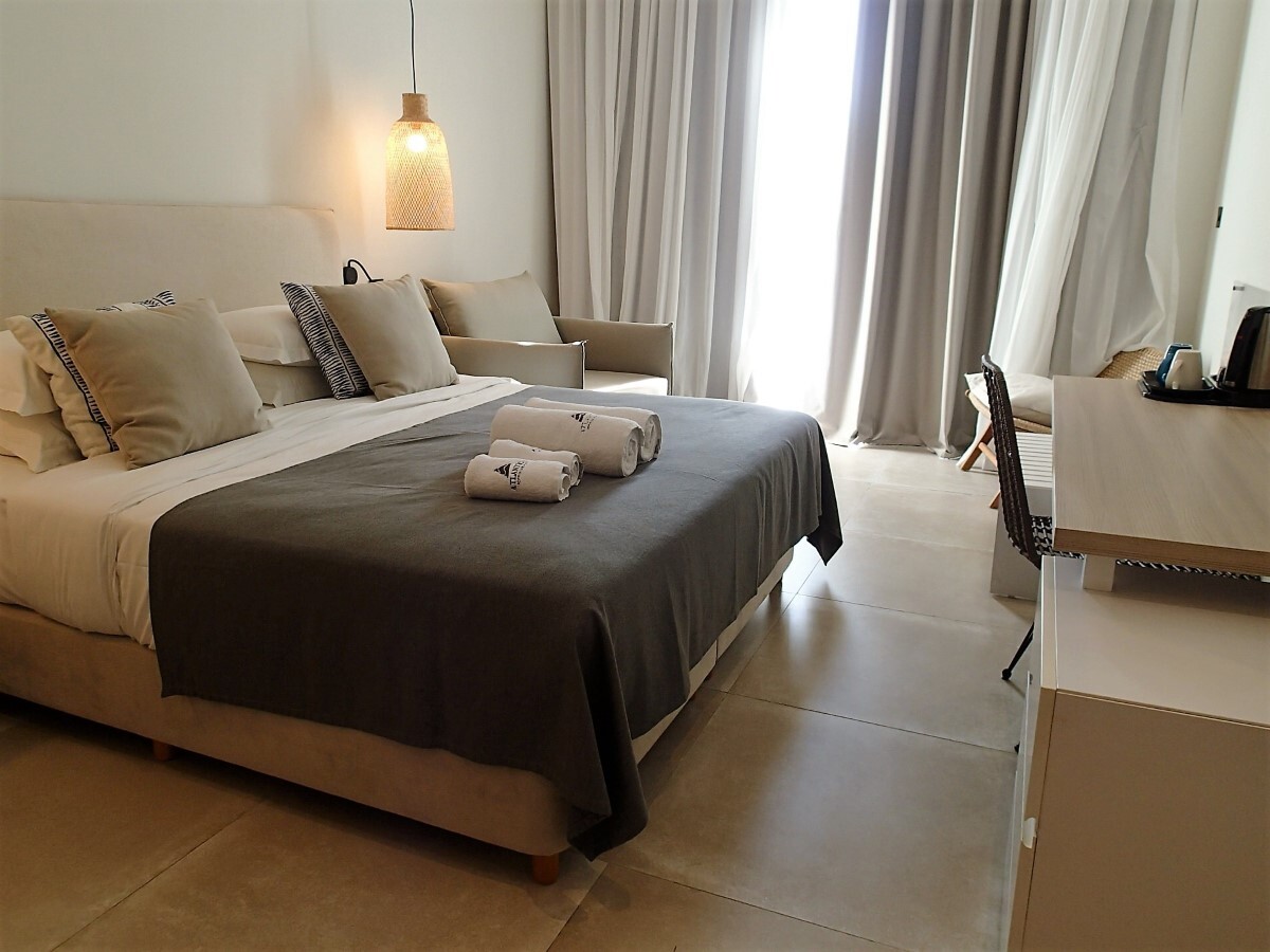 "Adapted room, shows bed, desk and balcony window, towels are used to decorate the bed further"