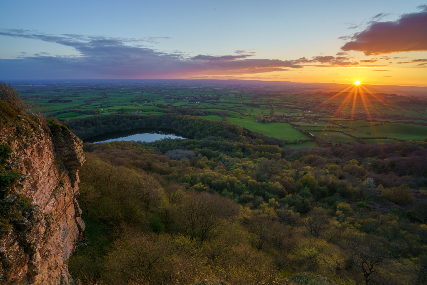 "View of Sutton Bank with an orange sun setting on the horizon"
