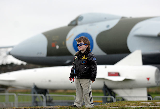 "Kid Standing in front of a plane "